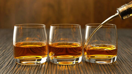 威士忌涌入一张小木桌上的玻璃
