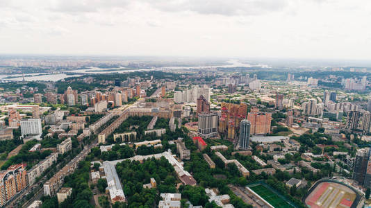 建筑物的鸟瞰图。基辅市。全景。夏天。阳光灿烂。一天。第聂伯河河。白色的天空。树。城市街道