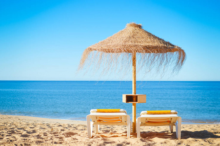 在葡萄牙阿尔加维，阳光明媚的户外背景海洋海滩上的稻草伞