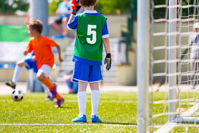 足球训练游戏的孩子小男孩作为一名足球守门员站在球门上足球运动员在