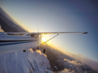 小飞机飞行上层建筑美丽的加拿大山风景在一个充满活力的日落期间。拍摄于加拿大不列颠哥伦比亚省温哥华以北