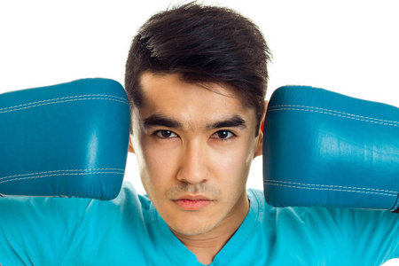 在蓝色的拳击手套，在白色背景上孤立的工作室年轻体育乔装的肖像
