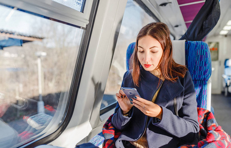 旅行者女孩使用手机在火车上, 旅游应用理念