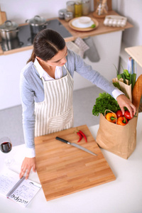 制作健康食品站在厨房里微笑的女人