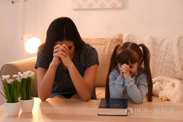 宗教基督徒女孩和她的母亲在家祈祷