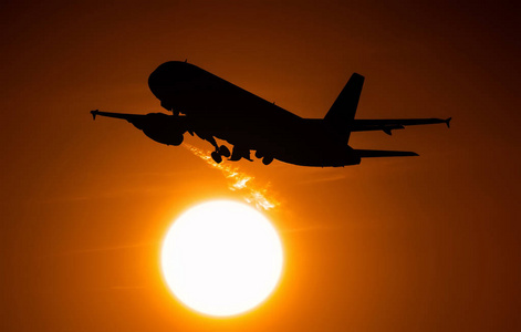 飞机飞过太阳圆盘的飞机起飞时，引擎会留下痕迹的热空气