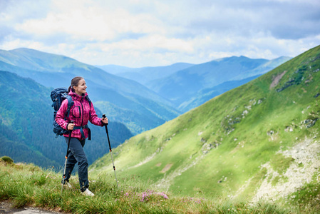 带着背包和徒步旅行的年轻女子在罗马尼亚的群山中远足。概念健康和积极的生活方式。女孩在自然背景与强的山