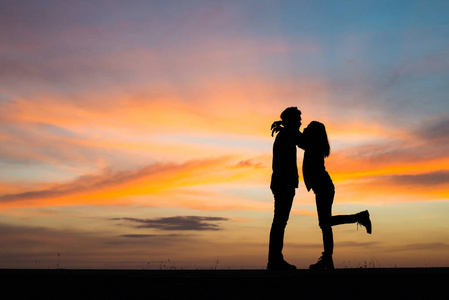 剪影年轻夫妇在爱享受美好的时间在一起在日落期间