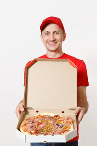 送微笑的人在红色制服被隔绝在白色背景。男性 pizzaman 在帽子, t恤工作作为信使或经销商持有意大利比萨在纸板 flatb