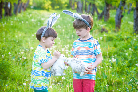 两个小的孩子男孩和朋友们在复活节兔子耳朵在 tra