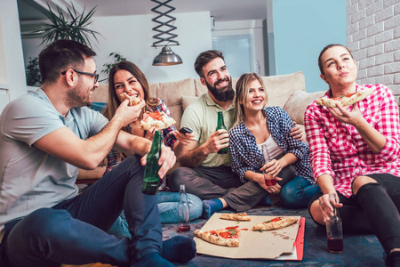 一群年轻的朋友吃披萨在家里聚会