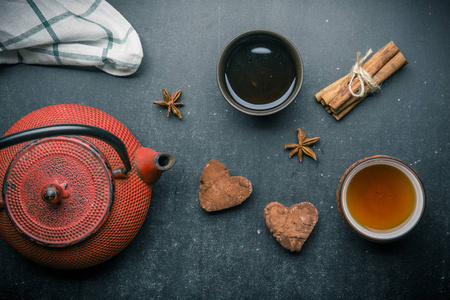 茶成分与棉花糖, 茶杯和传统茶壶在黑暗的背景下