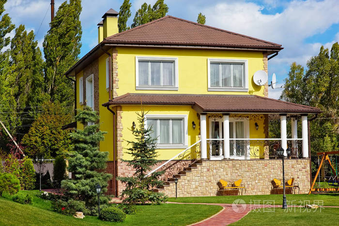 美丽的房子与绿色庭院和庭院的外部