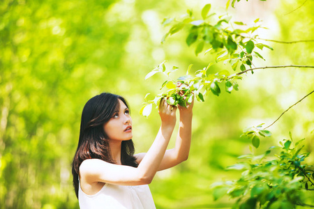 自然的绿色背景上的年轻女子的画像