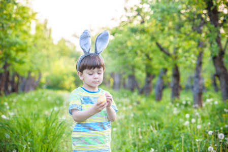 孩子在复活节彩蛋狩猎在盛开的春天花园。男孩搜索