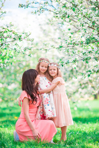 可爱的小女孩和妈妈在春日盛开树花园