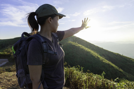 女游客用手捂住小山上阳光的亮光