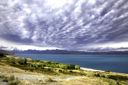 风景秀丽的蓝色水湖 Pukaki 和戏剧云彩在山在背景