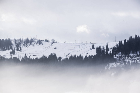 美丽的冬天景观在山上。日出。Carpatian 谷与雾和雪。喀尔巴阡山冬季。清晨光躺在山山顶上