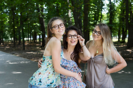 走在公园的三个美丽年轻的波西米亚风格别致时尚女孩