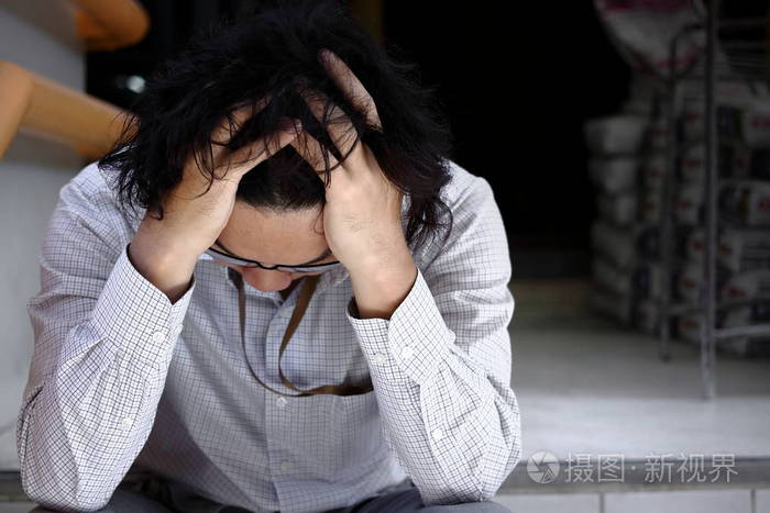 失意的年轻亚洲男人抚摸着头, 感到失望或疲惫.失业的生意人概念