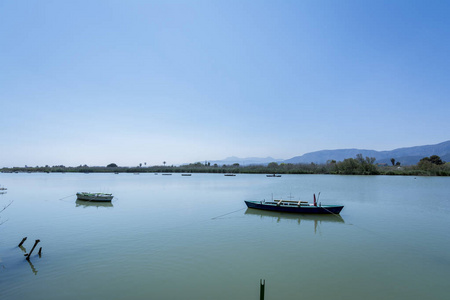 平静的湖面与两艘渔船。Estany 德库列拉的淡水咸水湖。瓦伦西亚西班牙