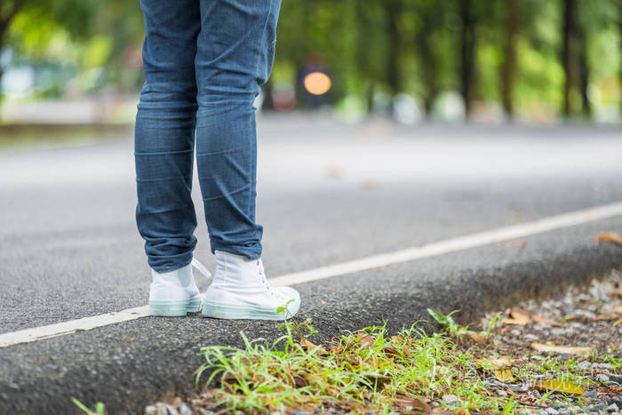 女子背包客步行站在乡间小路上