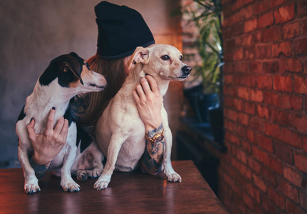 一个时尚的纹身金发女郎在 t恤和牛仔裤与她的狗
