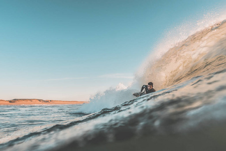 冲浪者骑着他的 bodyboard 的波浪