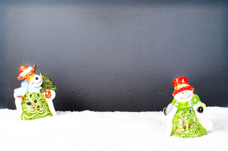 圣诞陶瓷雪人和木制背景与雪鹿。新年的装饰和玩具。文本的自由空间