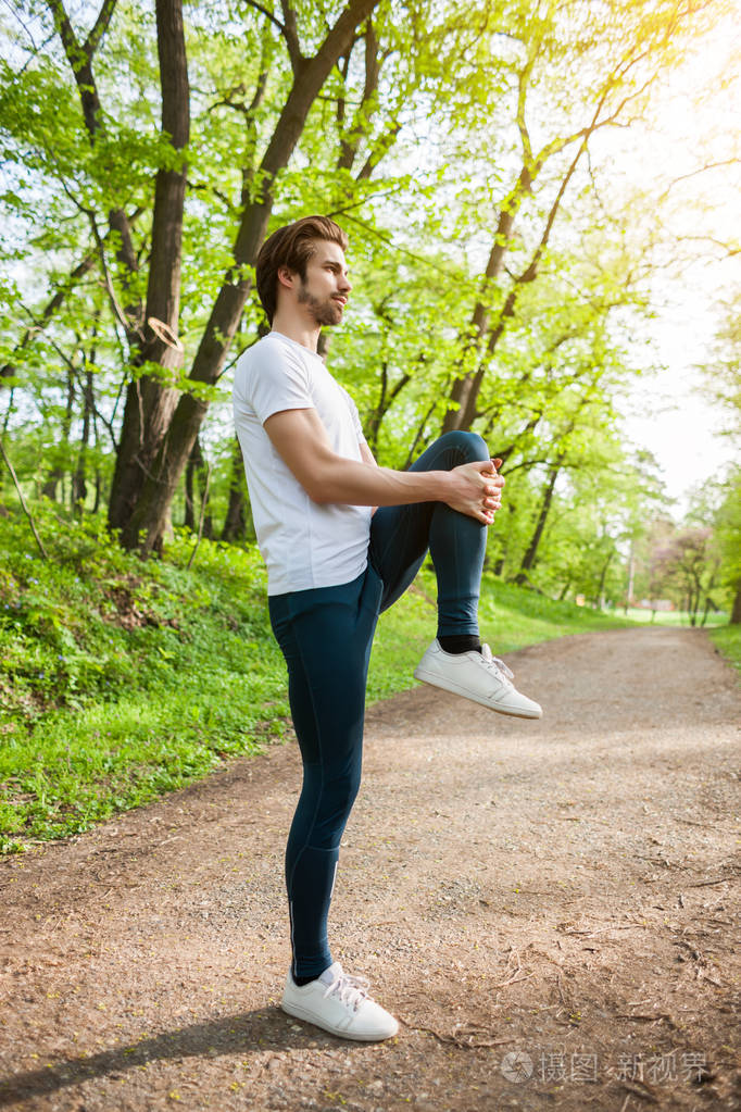 年轻人正在锻炼他在伸展身体