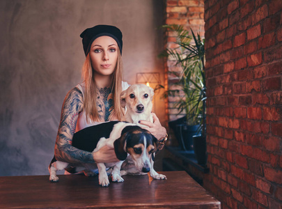 一个时髦的 tattoed 金发女在 t恤和牛仔裤与她的狗