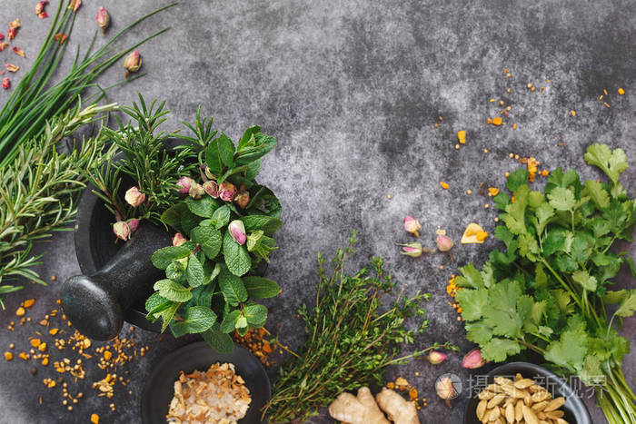 芳香的新鲜草本和香料在灰浆在黑暗的背景.顶部视图, 空白区域