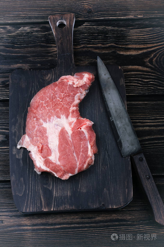 切菜板与肉和一把刀切片上旧的木制背景与文本的空间