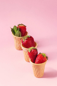 新鲜的草莓在华夫饼杯超过粉红色的蜡笔别针的背景。复制空间