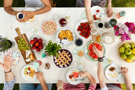 学生在户外吃一顿健康的饭菜, 在白色的餐桌上享受美好时光