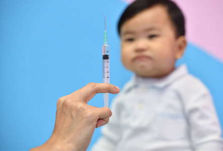 医生为亚洲婴儿在医院拿注射器注射疫苗