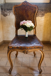 五颜六色的婚礼花束在老式椅子上