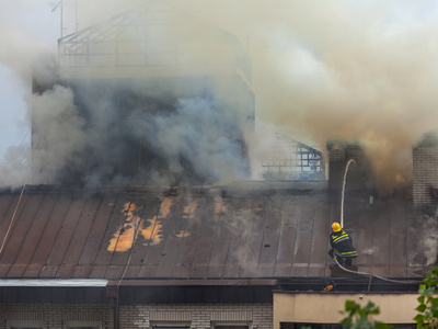 消防队员在灭火在屋顶上的工作图片