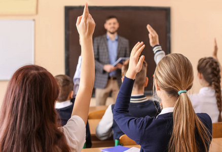 小学生听老师举手回答课堂图片