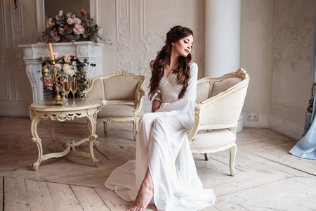美丽的新娘在白色婚礼 peignoir 在一个早晨。室内美画像