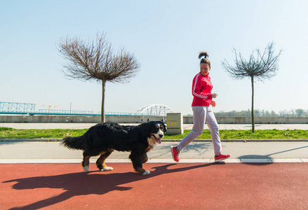 年轻漂亮的女孩与她恩山犬室外跑步