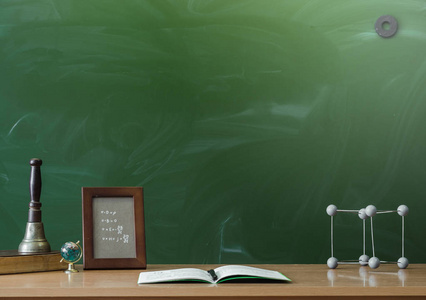 教育背景.教育理念.相框, 书, 抄写笔, 地球仪和上课铃在桌上照片