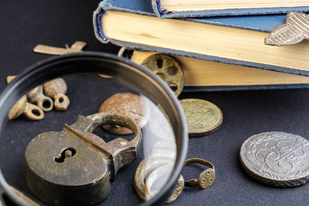 放大镜下被认为是一个旧的硬币和一本书的老铜挂锁