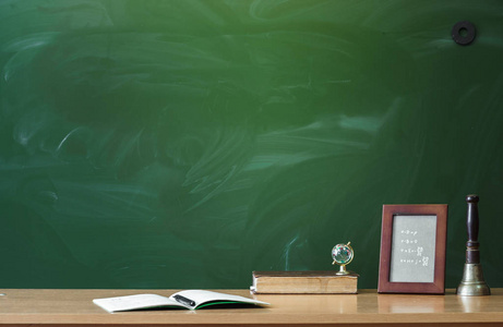 相框, 书, 抄写笔, 地球仪和上课铃在桌上小学生听老师举手回答课堂