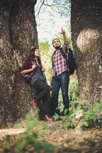 徒步旅行者夫妇在树之间散步。旅游理念