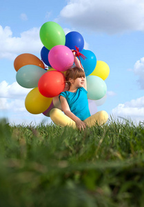 快乐的孩子，玩着五颜六色的玩具气球在户外