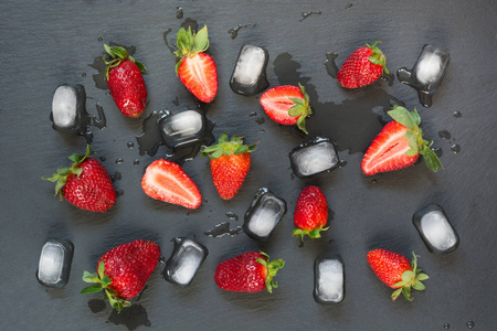 新鲜有机草莓在黑色石板背景。平躺