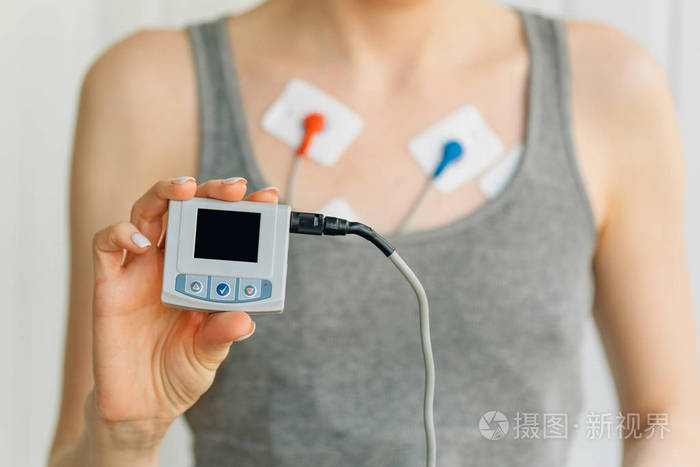 女士佩戴动态心电图监测仪.心脏病的治疗照片-正版商用图片0n7i7p-摄