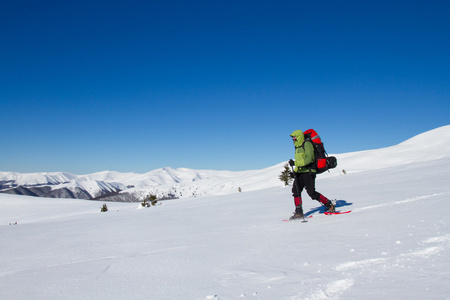 在山里徒步旅行带着背包和帐篷雪的冬天